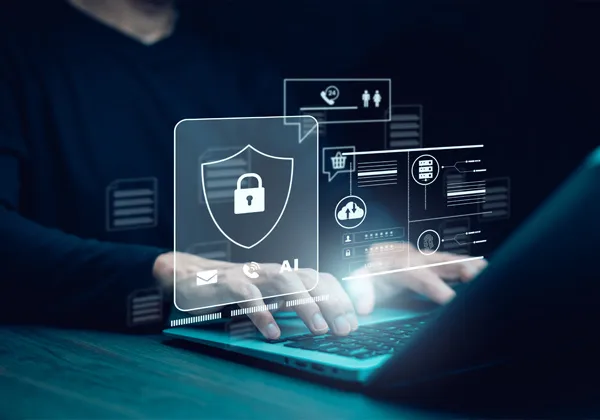 a well-dressed man sits in front of his laptop in a dark room. Graphics of cyber security float up around the keyboard.